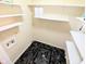 Functional laundry room with black marble-look floors and practical white shelving for optimal organization at 4619 Mac Dr, Anderson, IN 46013