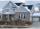 Two-story home with gray siding, brick accents, and a three-car garage at 6973 Oakdale Ln, Avon, IN 46123