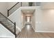 Bright hallway featuring hardwood floors and a staircase with iron railings at 6973 Oakdale Ln, Avon, IN 46123