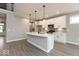 Bright kitchen with stainless appliances, center island, pendant lighting, and wood flooring at 6973 Oakdale Ln, Avon, IN 46123