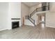 Open concept living room with a modern fireplace, hardwood floors and stylish stairs at 6973 Oakdale Ln, Avon, IN 46123