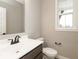 Powder room features vanity with modern faucet, toilet and a bright window at 6973 Oakdale Ln, Avon, IN 46123