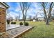 Expansive backyard with a concrete patio and green grass surrounded by mature trees at 7330 Tousley Dr, Indianapolis, IN 46256