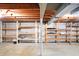 Unfinished basement with exposed wood ceiling, concrete floor, and built-in shelving at 7330 Tousley Dr, Indianapolis, IN 46256