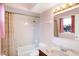 Tiled bathroom featuring a shower-tub combo and vanity with decorative mirror and lighting at 7330 Tousley Dr, Indianapolis, IN 46256