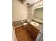 Classic half bathroom with wooden vanity, laminate flooring, and unique seashell decorated wallpaper at 7330 Tousley Dr, Indianapolis, IN 46256