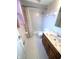 Tiled bathroom showcases a vanity with dark wood cabinets, sink, mirror, and shower-tub combo at 7330 Tousley Dr, Indianapolis, IN 46256