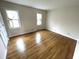 Comfortable bedroom with gleaming hardwood floors and bright natural light from two windows at 7330 Tousley Dr, Indianapolis, IN 46256