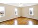 Bright bedroom features gleaming hardwood floors, neutral walls, and two large windows with white curtains at 7330 Tousley Dr, Indianapolis, IN 46256