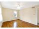 Sunlit bedroom with gleaming hardwood floors, ceiling fan, and a bright window view at 7330 Tousley Dr, Indianapolis, IN 46256