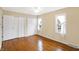 Well-lit bedroom features hardwood floors, double closets, fan, and natural light at 7330 Tousley Dr, Indianapolis, IN 46256