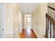 Bright hallway with wood floors and white trim detail leading to stairs and a living room at 7330 Tousley Dr, Indianapolis, IN 46256