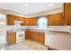 Functional kitchen with classic wood cabinetry, white appliances, and tile flooring at 7330 Tousley Dr, Indianapolis, IN 46256