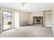 Open living room with a brick fireplace, built-in shelving, and sliding glass door to the backyard at 7330 Tousley Dr, Indianapolis, IN 46256
