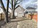 Backyard view showing a large tree, small grassy area and a wooden fence at 1715 Union St, Indianapolis, IN 46225
