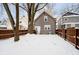 House backyard view with snow, large trees, and fence at 1715 Union St, Indianapolis, IN 46225