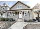 Charming two-story home with a welcoming front porch and gray painted brick and siding at 1715 Union St, Indianapolis, IN 46225