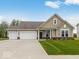 Charming single-story home features a three-car garage, beautiful lawn, and neutral siding at 310 N Bur Oak Dr, Mooresville, IN 46158