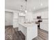 Well-lit kitchen with white cabinets, stainless steel appliances, and a spacious island at 310 N Bur Oak Dr, Mooresville, IN 46158