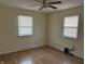 Bright bedroom featuring hardwood floors, two windows, and a ceiling fan at 6085 Manning Rd, Indianapolis, IN 46228