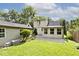 Backyard view with green grass, well manicured landscaping, a patio and sunroom at 6348 Kingsley Dr, Indianapolis, IN 46220