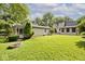 Manicured backyard featuring a brick fire pit, green grass, mature trees, and privacy at 6348 Kingsley Dr, Indianapolis, IN 46220