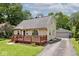 Exterior view of a home with a deck, detached garage, and a well-manicured lawn at 6348 Kingsley Dr, Indianapolis, IN 46220