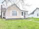 Cozy home featuring light siding, a well-maintained lawn, and a classic front door with adjacent windows at 810 W 2Nd St, Anderson, IN 46016