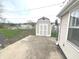 A detached shed with painted wood-look siding sits on a concrete pad, surrounded by a chain link fence at 810 W 2Nd St, Anderson, IN 46016