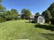 Large backyard with green grass, a shed, and trees at 11720 Grenadier Ln, Indianapolis, IN 46229