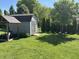 Backyard featuring a wooden shed with a covered woodpile and surrounding greenery at 11720 Grenadier Ln, Indianapolis, IN 46229