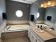 Elegant bathroom featuring a soaking tub, vanity, and stylish lighting fixtures at 11720 Grenadier Ln, Indianapolis, IN 46229