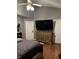 This bedroom features a large TV, light wood dresser and dark hardwood flooring at 11720 Grenadier Ln, Indianapolis, IN 46229
