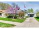 Quaint home featuring mature flowering trees, detached garage, and manicured lawn at 1641 Winton Ave, Indianapolis, IN 46224