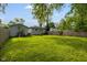 Spacious backyard featuring a lush lawn, wooden fence, detached garage, and inviting fire pit at 3125 N Tacoma Ave, Indianapolis, IN 46218