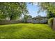 Spacious backyard featuring a lush lawn, wooden fence, detached garage, and inviting fire pit at 3125 N Tacoma Ave, Indianapolis, IN 46218