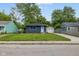 Charming single-story home featuring a well-maintained lawn, blue door, and convenient detached garage at 3125 N Tacoma Ave, Indianapolis, IN 46218