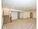 Spacious carpeted basement with neutral walls and access to the stairwell at 6596 Dogwood Dr, McCordsville, IN 46055