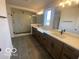 Elegant bathroom with wood cabinets, double sinks, tiled floors, and a glass shower enclosure at 6596 Dogwood Dr, McCordsville, IN 46055