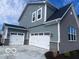 Exterior features a three car garage, stone and siding accents for enhanced curb appeal at 6596 Dogwood Dr, McCordsville, IN 46055