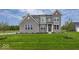 Inviting two-story home with a well-manicured lawn and classic gray brick facade at 6596 Dogwood Dr, McCordsville, IN 46055