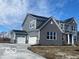 Stunning exterior features a 3-car garage, stone and siding accents for enhanced curb appeal at 6596 Dogwood Dr, McCordsville, IN 46055