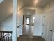Bright hallway with hardwood floors leads to an open living area with a black framed door at 6596 Dogwood Dr, McCordsville, IN 46055
