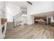Open-concept living room with a fireplace and a staircase, flowing into the kitchen at 6596 Dogwood Dr, McCordsville, IN 46055