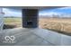 Covered patio featuring concrete flooring, a brick fireplace, and scenic views of the surrounding landscape at 6596 Dogwood Dr, McCordsville, IN 46055