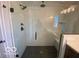 Contemporary walk-in shower featuring modern fixtures, marble walls, black tile flooring, and a glass enclosure at 6596 Dogwood Dr, McCordsville, IN 46055