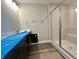 Modern bathroom with dark vanity, large shower with glass doors, and wood-look flooring at 7340 W County Road 600 Rd, McCordsville, IN 46055