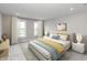 Bright bedroom with two windows, a bed with decorative pillows and minimalist nightstands at 7340 W County Road 600 Rd, McCordsville, IN 46055