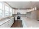 Bright kitchen featuring white cabinets, stainless steel appliances, a large island, and wood-look flooring at 7340 W County Road 600 Rd, McCordsville, IN 46055