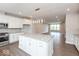 Modern open concept kitchen with large island, white cabinets, and wood floors adjoins living area at 7340 W County Road 600 Rd, McCordsville, IN 46055